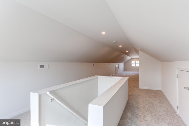 corridor with an upstairs landing, light carpet, lofted ceiling, recessed lighting, and baseboards