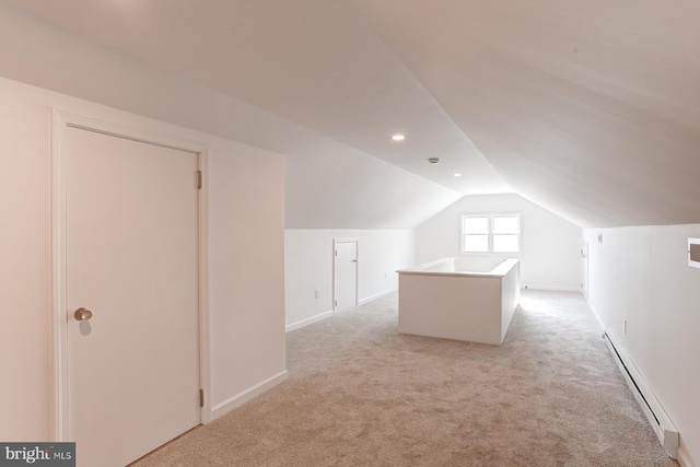 bonus room featuring a baseboard heating unit, lofted ceiling, and light colored carpet