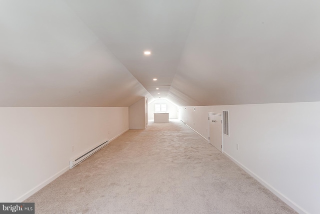 additional living space featuring baseboards, visible vents, carpet floors, a baseboard radiator, and vaulted ceiling