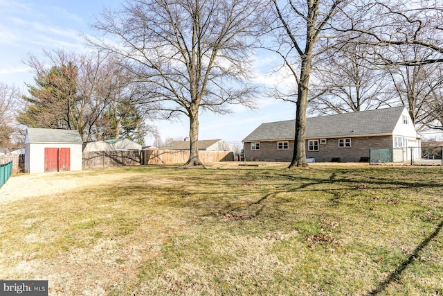 view of yard featuring an outdoor structure, a fenced backyard, and a storage shed