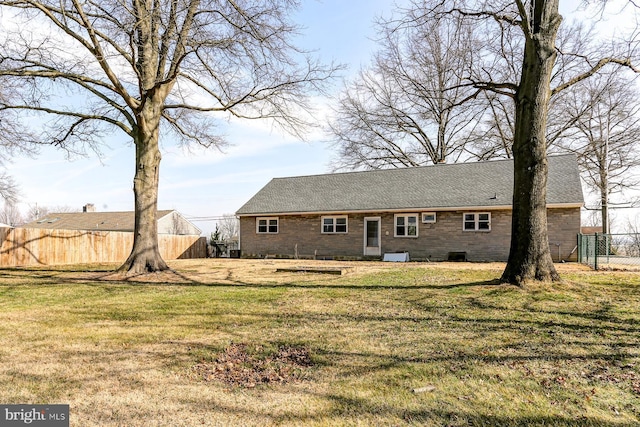 back of property with a yard and fence