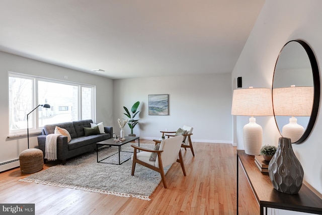 living room featuring light wood-type flooring, baseboards, and a baseboard radiator