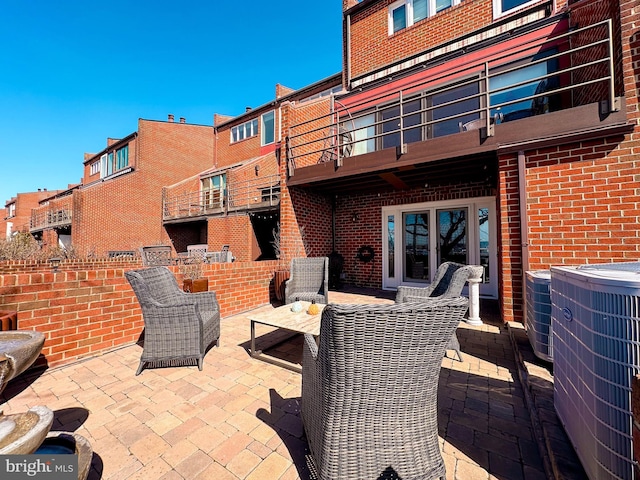 view of patio featuring central AC unit and a balcony