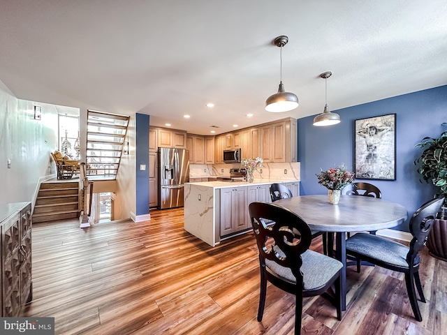 dining room with recessed lighting, stairway, baseboards, and light wood finished floors