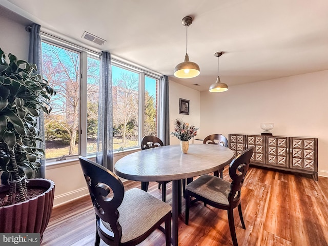 dining area with visible vents, baseboards, and wood finished floors