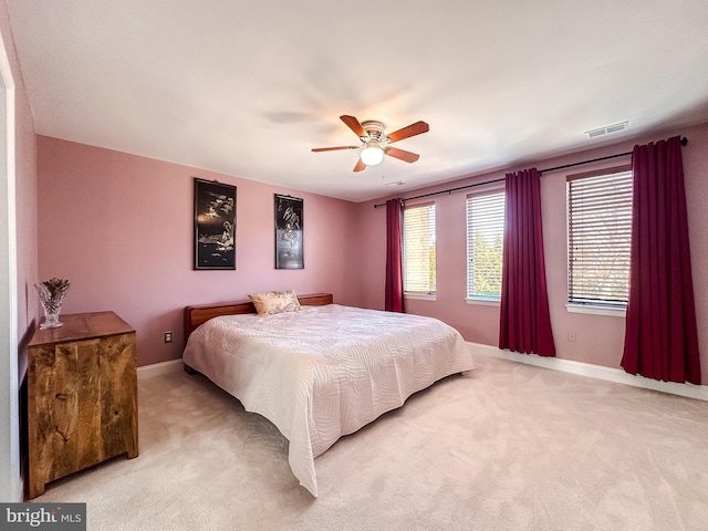 bedroom with light carpet, visible vents, and baseboards