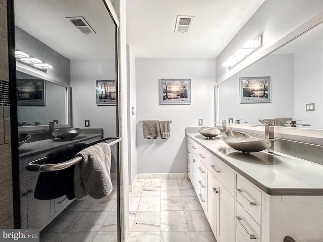 bathroom with a sink, visible vents, marble finish floor, and double vanity