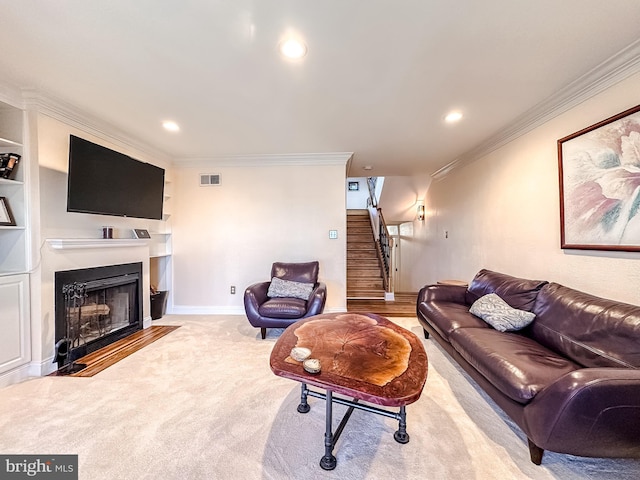 living room with built in features, visible vents, a fireplace with flush hearth, stairs, and crown molding