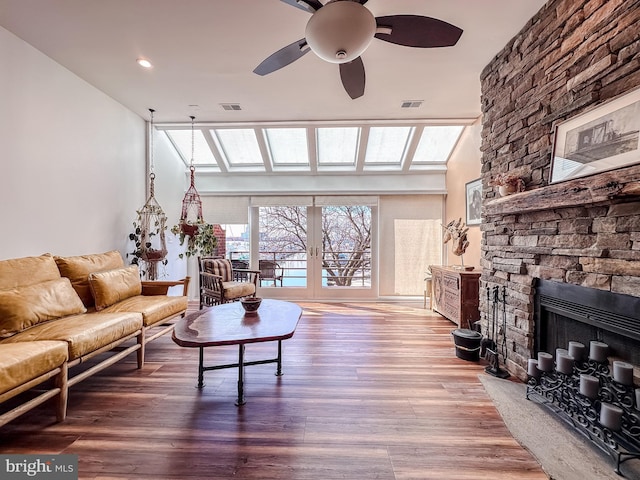 living room featuring visible vents, french doors, ceiling fan, and wood finished floors