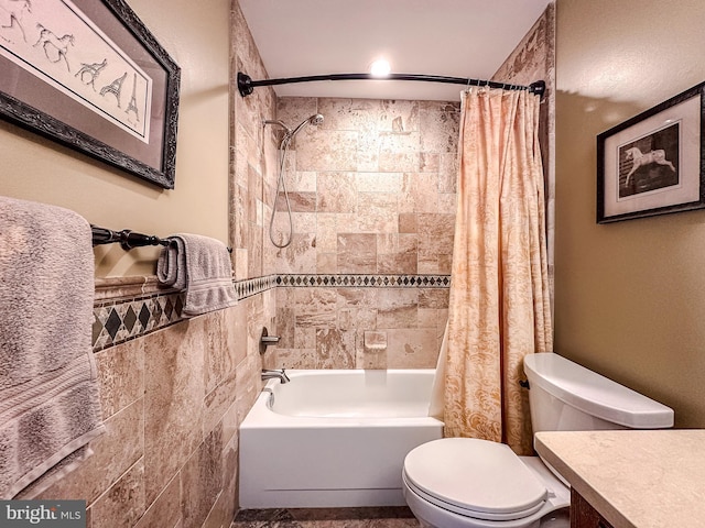 bathroom with vanity, tile walls, toilet, and shower / bath combo