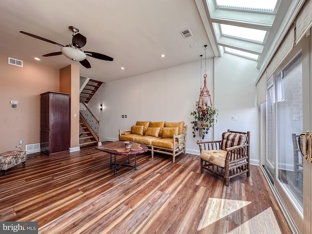 living area with visible vents, stairway, baseboards, and wood finished floors