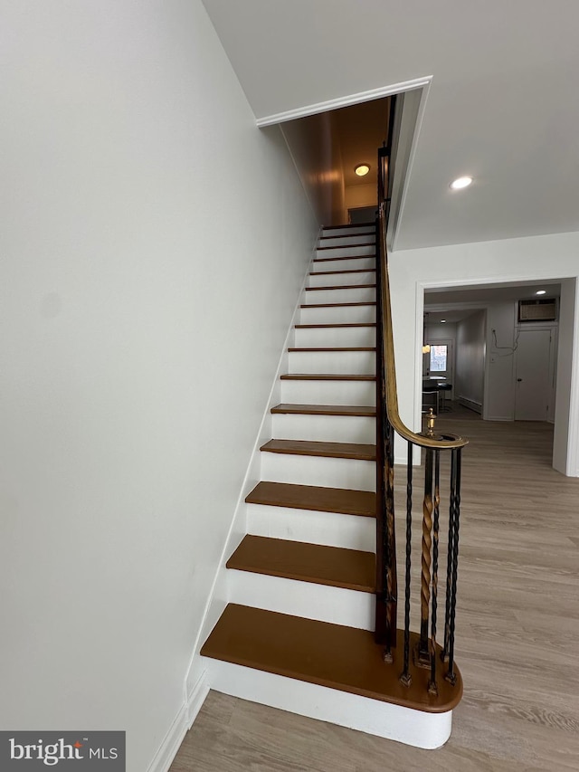 stairway featuring recessed lighting, baseboards, and wood finished floors