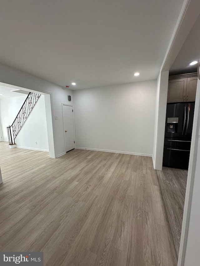 unfurnished living room with recessed lighting, stairway, baseboards, and light wood finished floors