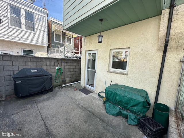 view of patio / terrace with a grill and fence