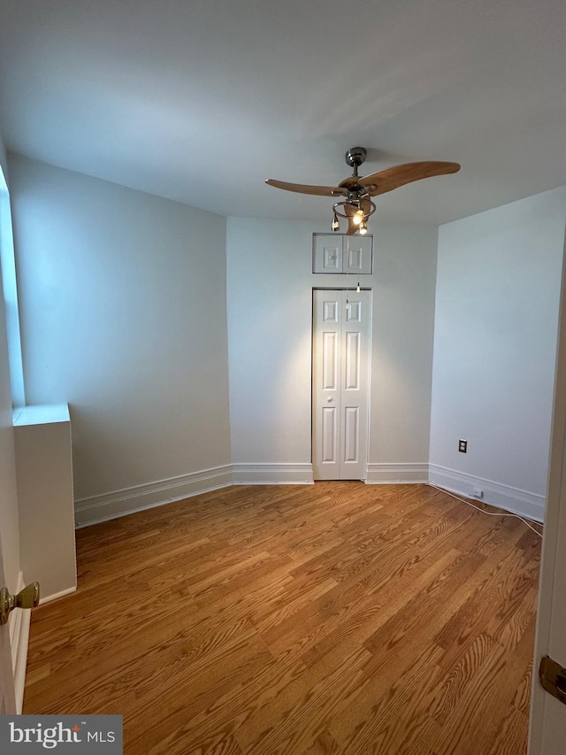 empty room featuring baseboards, ceiling fan, and light wood finished floors