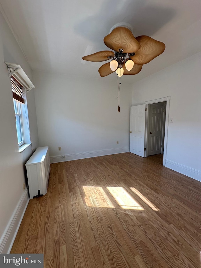 unfurnished bedroom featuring light wood-style flooring, baseboards, and ceiling fan