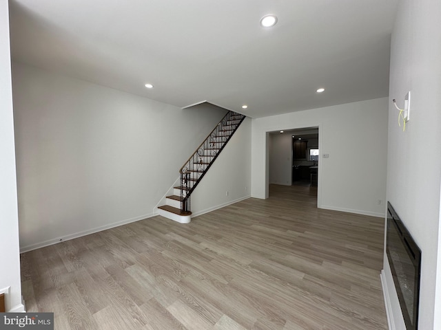 unfurnished living room featuring stairway, recessed lighting, light wood-type flooring, and baseboards