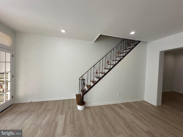 stairway with recessed lighting, baseboards, and wood finished floors