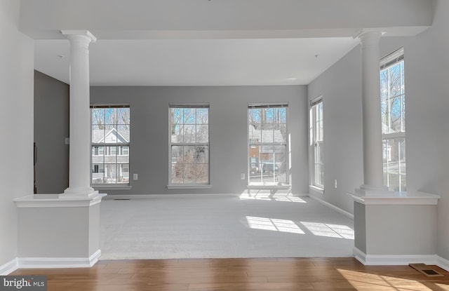 interior space featuring a healthy amount of sunlight and ornate columns