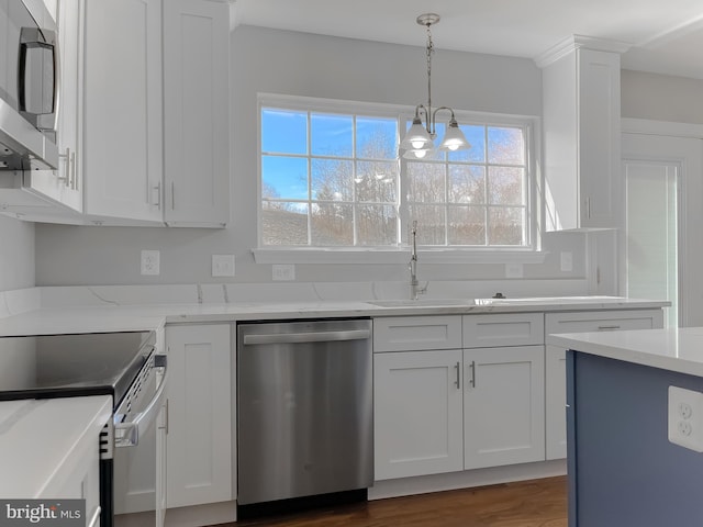 kitchen with a chandelier, light stone counters, appliances with stainless steel finishes, hanging light fixtures, and white cabinets