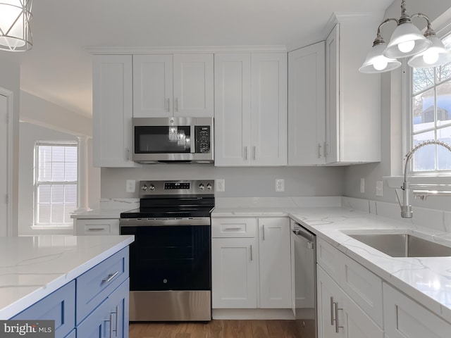 kitchen with a sink, stainless steel appliances, and white cabinets