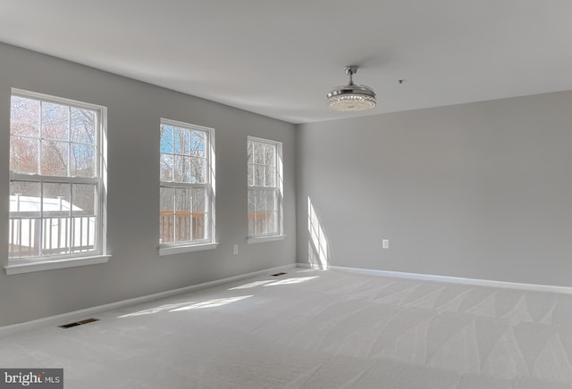 carpeted empty room featuring visible vents and baseboards