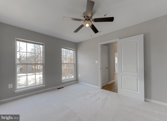 unfurnished bedroom featuring carpet flooring, baseboards, visible vents, and ceiling fan