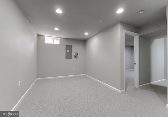 below grade area featuring light carpet, recessed lighting, and baseboards