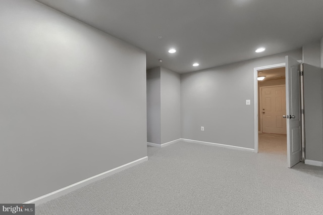 basement featuring recessed lighting, baseboards, and light colored carpet