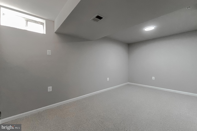 basement featuring carpet, visible vents, and baseboards