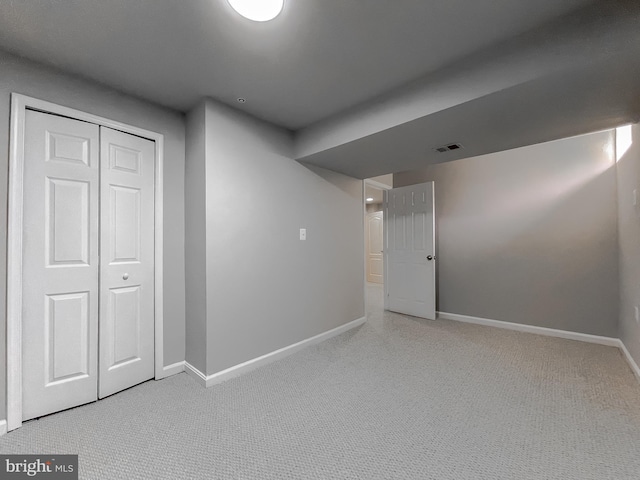 below grade area with carpet flooring, baseboards, and visible vents