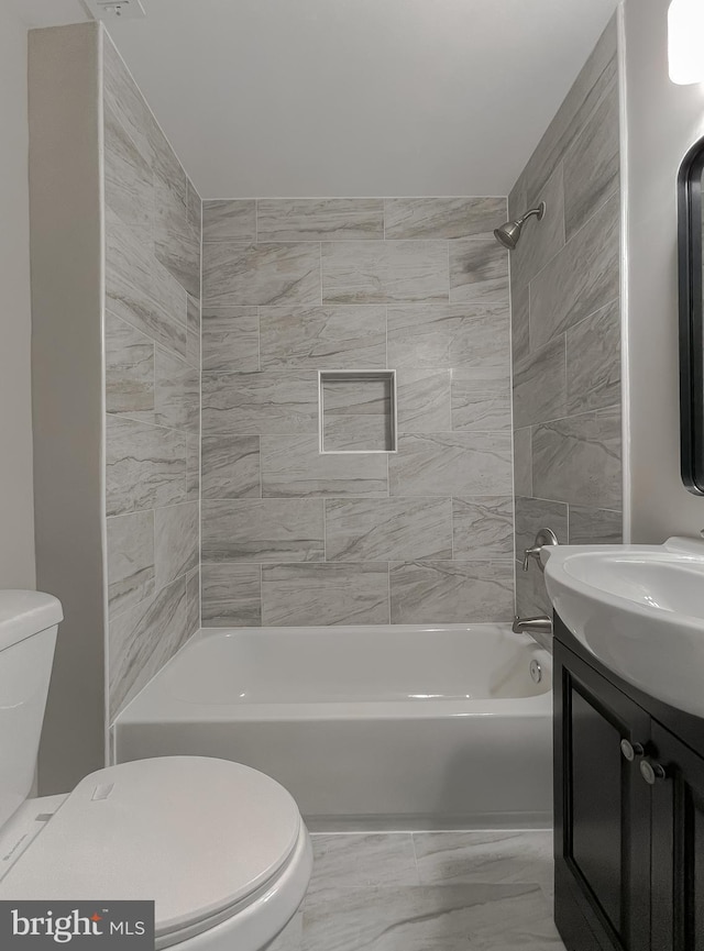 full bath featuring marble finish floor, toilet, vanity, and washtub / shower combination