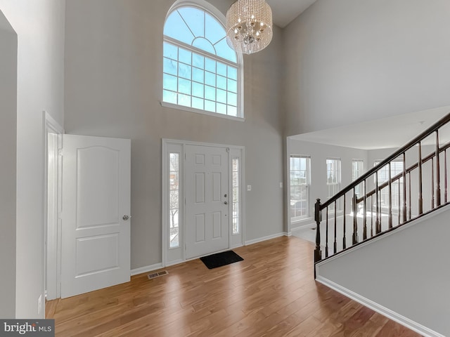 entryway featuring stairs, wood finished floors, visible vents, and a wealth of natural light