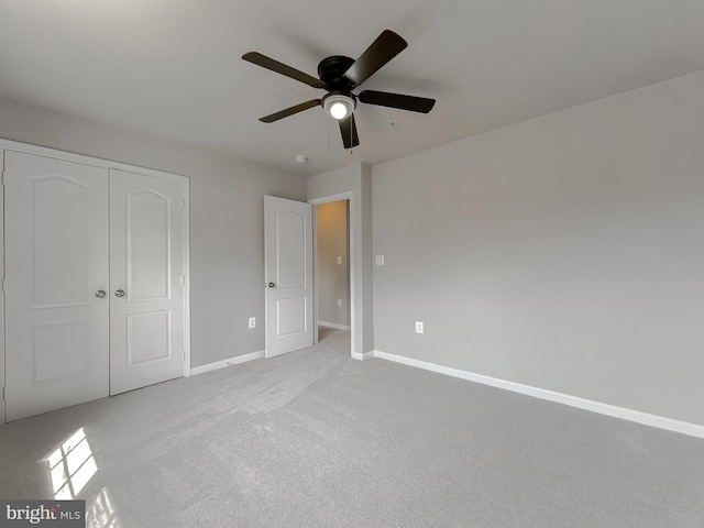 unfurnished bedroom with a closet, baseboards, carpet floors, and a ceiling fan