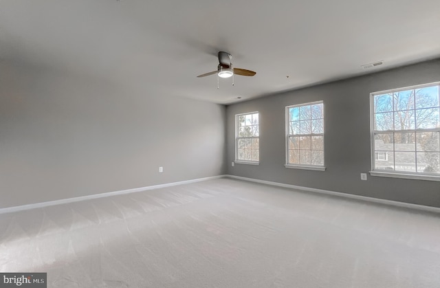 unfurnished room featuring visible vents, light carpet, baseboards, and a ceiling fan