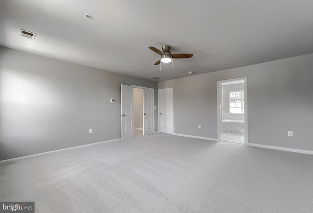 carpeted empty room featuring a ceiling fan, visible vents, and baseboards