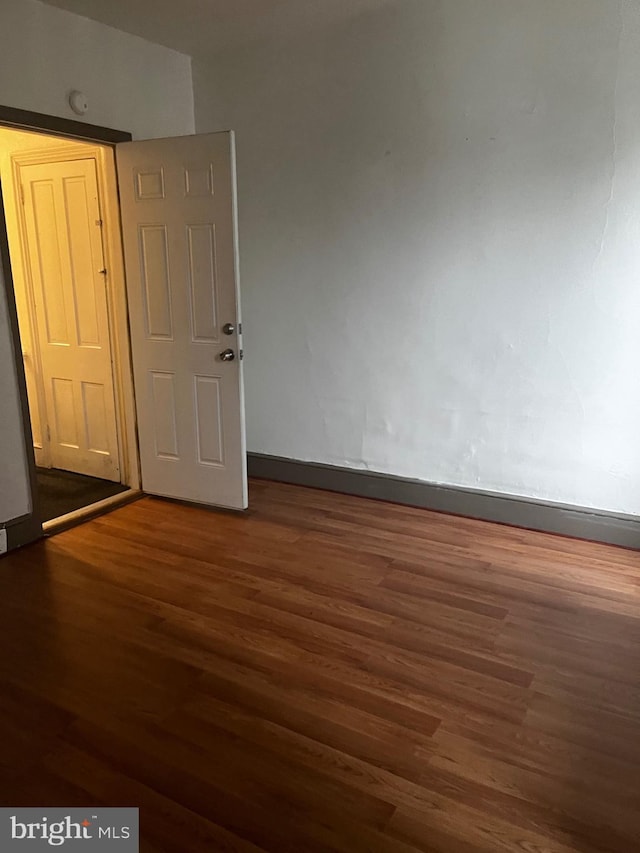 empty room featuring wood finished floors and baseboards