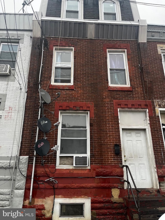 view of home's exterior with cooling unit and brick siding