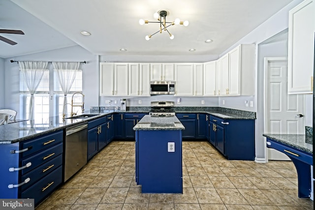 kitchen featuring blue cabinetry, a center island, white cabinets, stainless steel appliances, and a sink