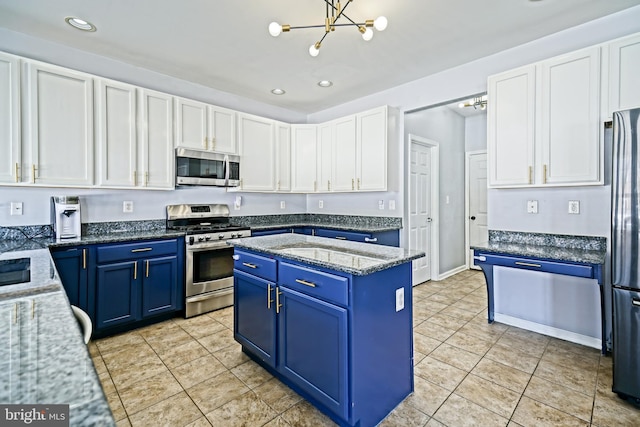 kitchen with blue cabinetry, light tile patterned floors, appliances with stainless steel finishes, a notable chandelier, and white cabinetry