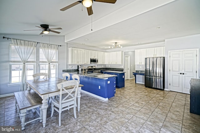 kitchen featuring blue cabinets, appliances with stainless steel finishes, ceiling fan, and white cabinets