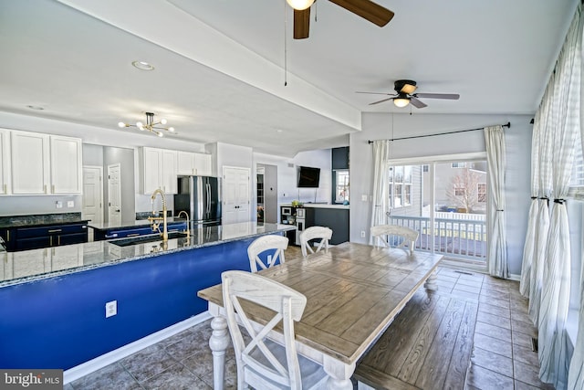 dining room featuring baseboards, lofted ceiling, and ceiling fan