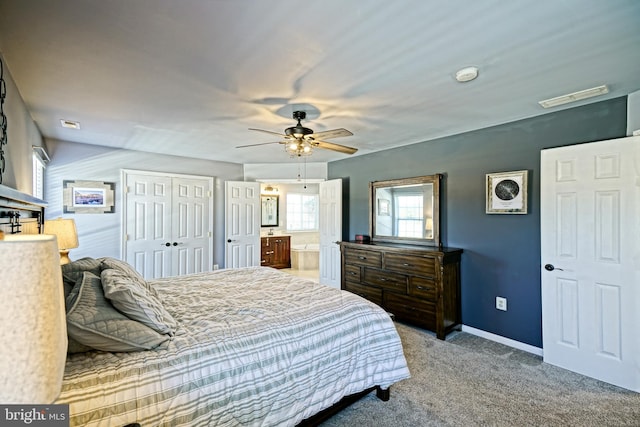 bedroom with visible vents, connected bathroom, carpet flooring, baseboards, and ceiling fan