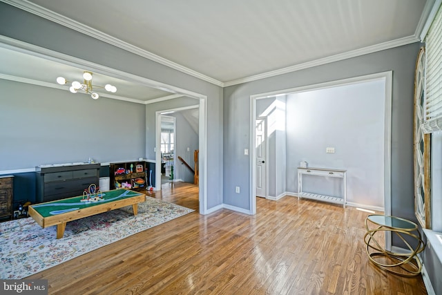 interior space featuring crown molding, baseboards, and wood finished floors