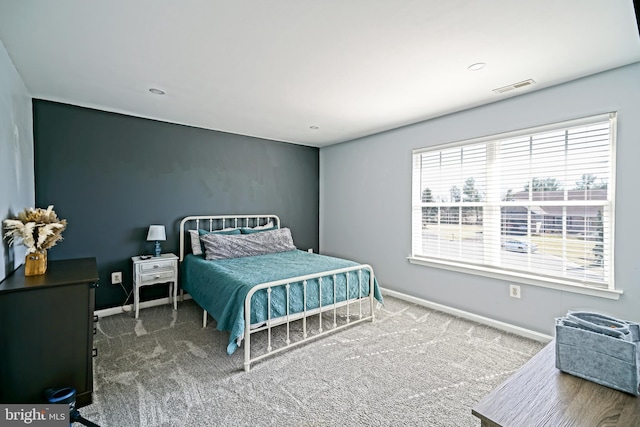 carpeted bedroom featuring visible vents and baseboards