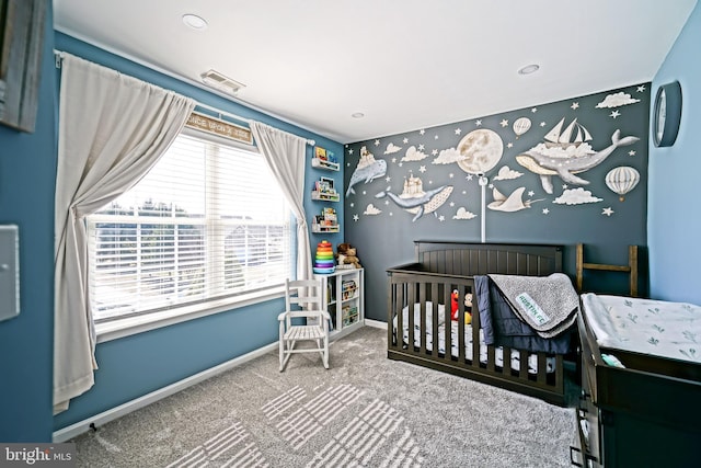 carpeted bedroom featuring visible vents, a crib, and baseboards