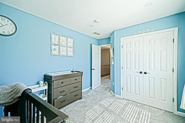 bedroom with carpet flooring, baseboards, visible vents, and a closet