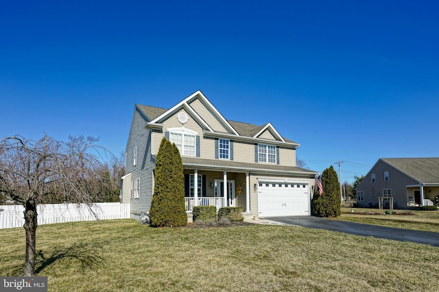 traditional home featuring a front lawn, fence, aphalt driveway, covered porch, and a garage