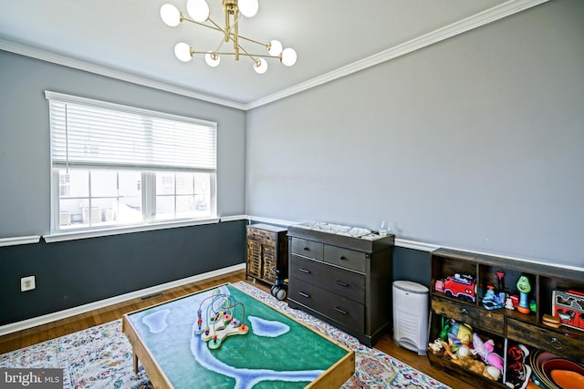 recreation room with visible vents, baseboards, a chandelier, ornamental molding, and wood finished floors