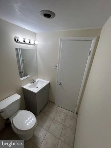 bathroom featuring vanity, toilet, and tile patterned flooring